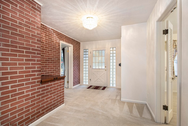 entrance foyer featuring light colored carpet and brick wall