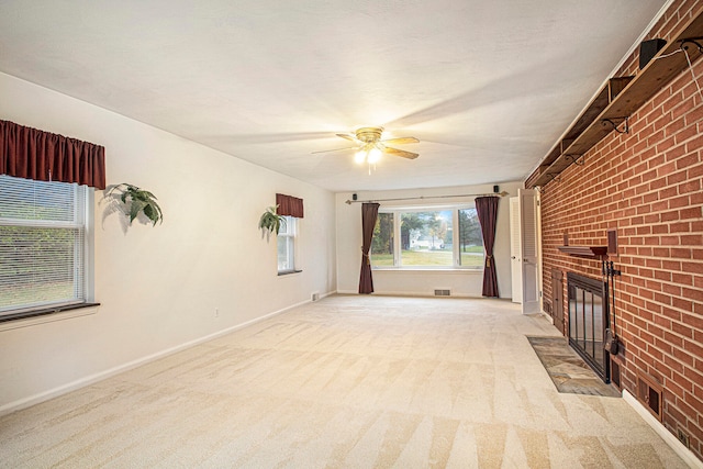 unfurnished living room featuring a fireplace, ceiling fan, light carpet, and brick wall