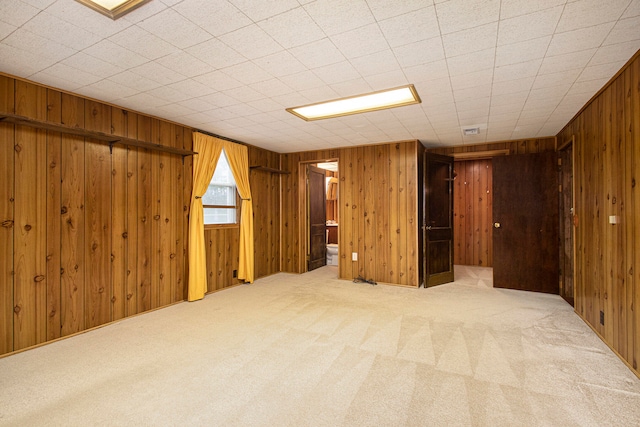 basement with carpet and wooden walls