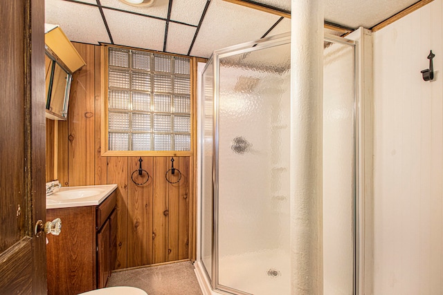 bathroom with vanity, wood walls, and walk in shower