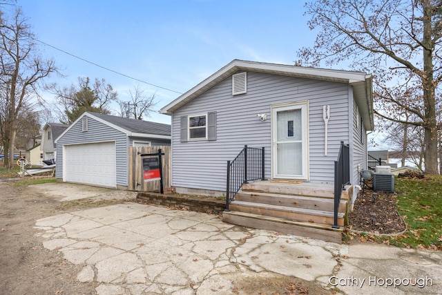 view of front of house featuring a garage, an outdoor structure, and central air condition unit