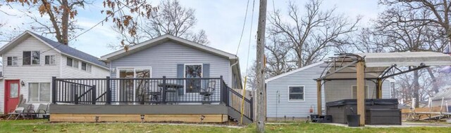 rear view of house with a lawn and a wooden deck