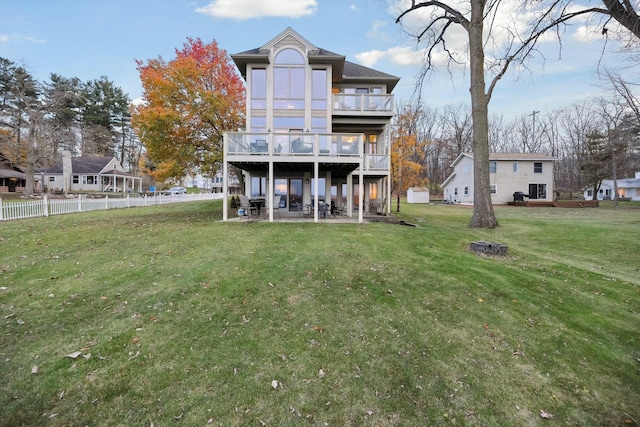 back of house with a yard, a balcony, a patio area, and a wooden deck