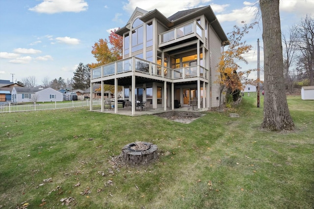 back of house with a patio area, a yard, an outdoor fire pit, and a deck