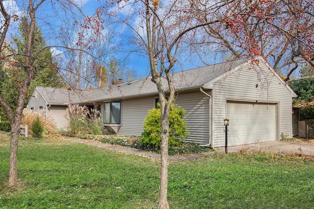 view of side of property with a garage and a lawn