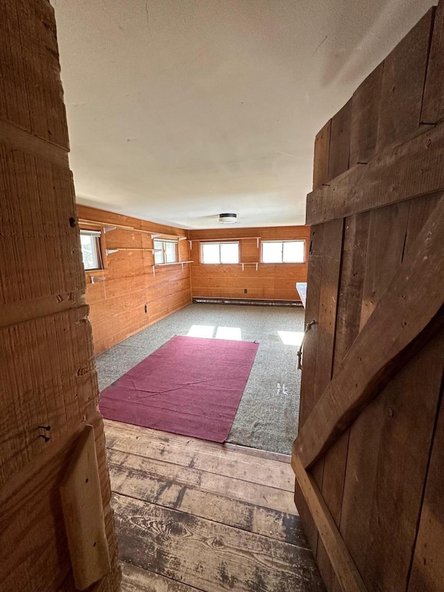 spare room featuring a baseboard heating unit and wooden walls