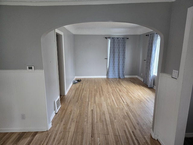 empty room featuring crown molding and light hardwood / wood-style floors