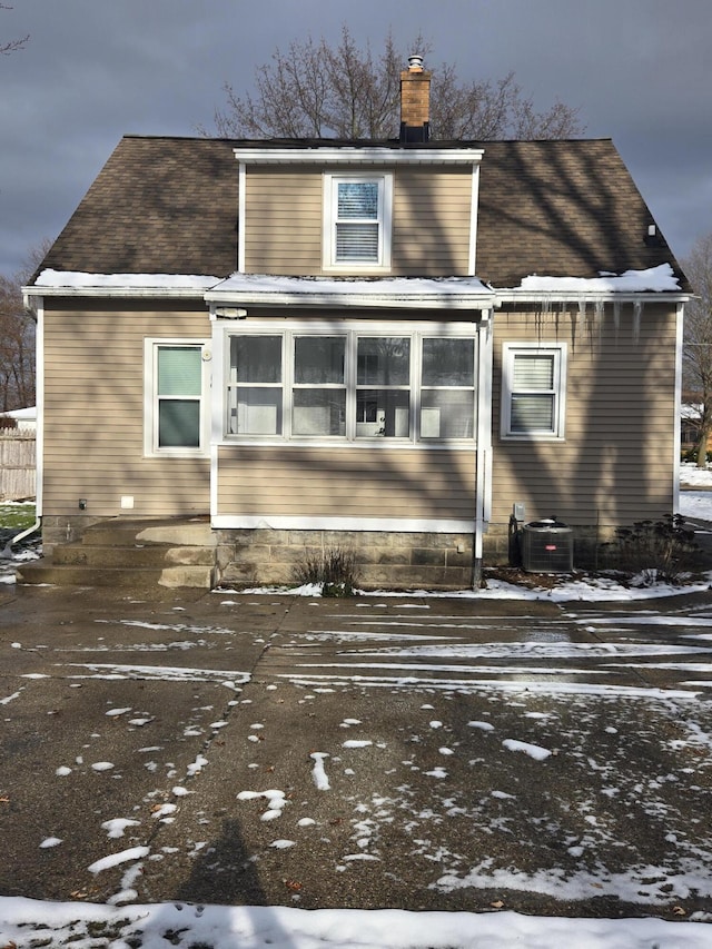 snow covered back of property with central air condition unit