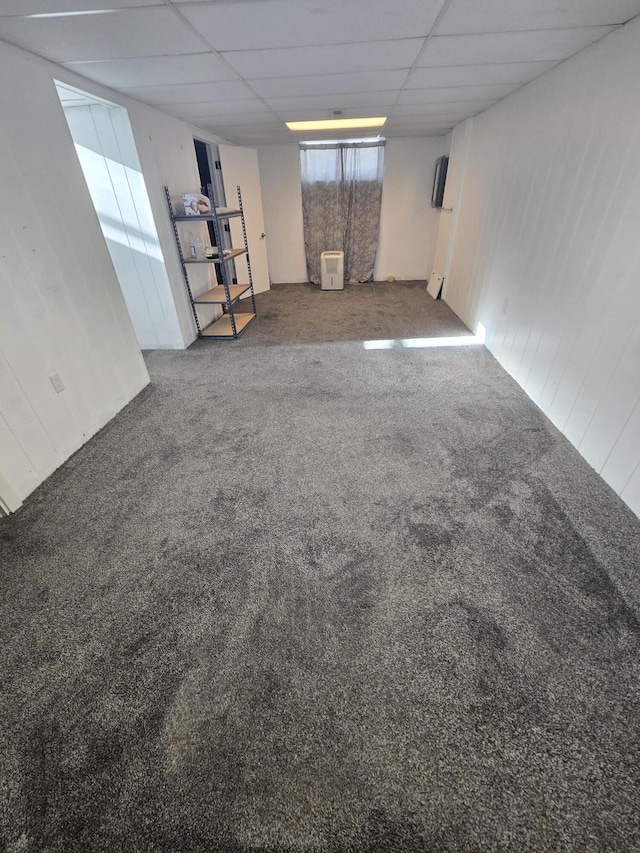 basement featuring carpet and a drop ceiling