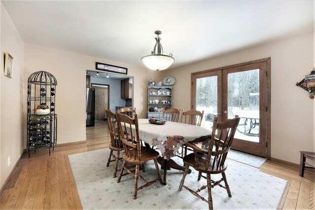 dining space featuring light hardwood / wood-style flooring and french doors