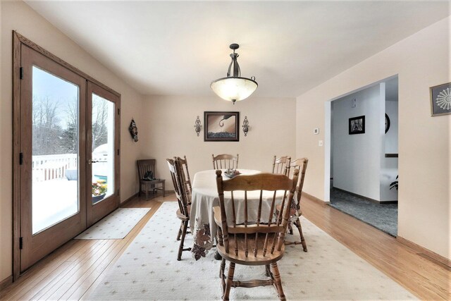 dining room with french doors and light hardwood / wood-style floors