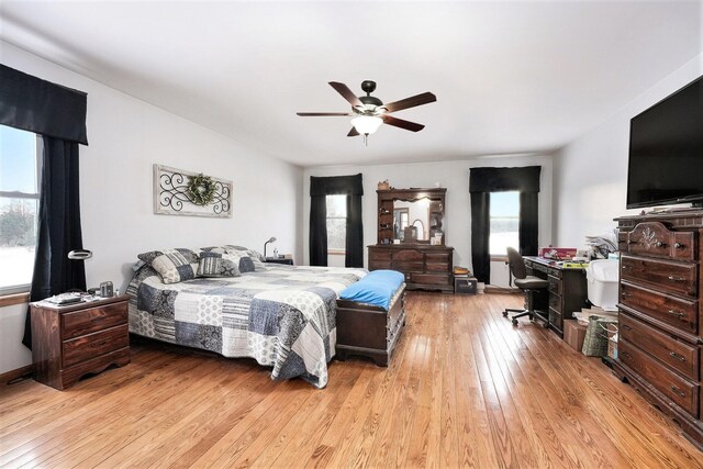 bedroom with ceiling fan, light hardwood / wood-style floors, and multiple windows