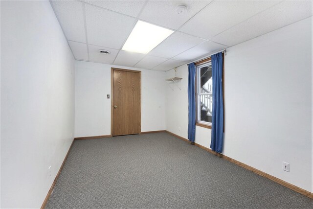 spare room with a paneled ceiling and carpet floors