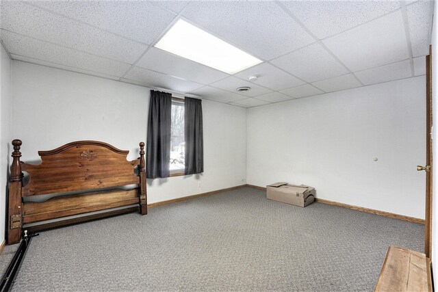 bedroom with carpet flooring and a drop ceiling