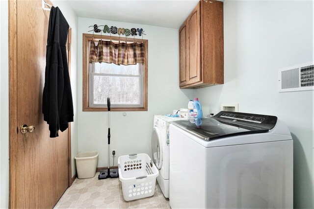 washroom featuring washer and clothes dryer and cabinets