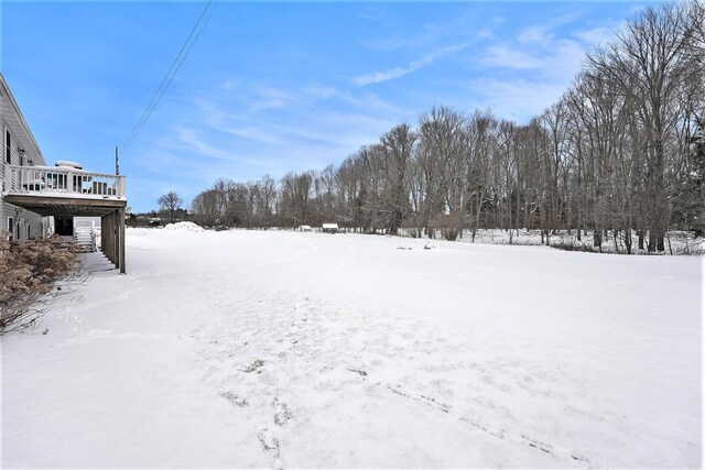 yard covered in snow featuring a wooden deck