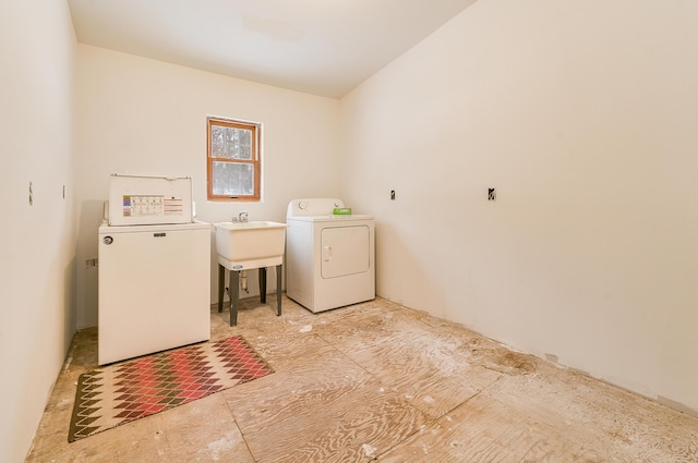 clothes washing area with separate washer and dryer and sink