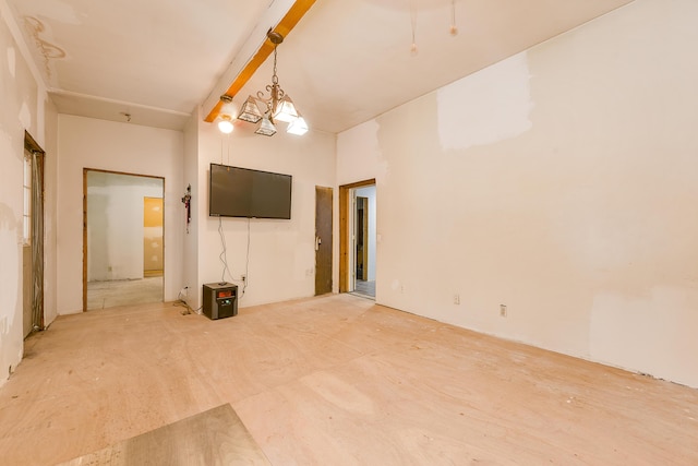 spare room with beam ceiling and a chandelier