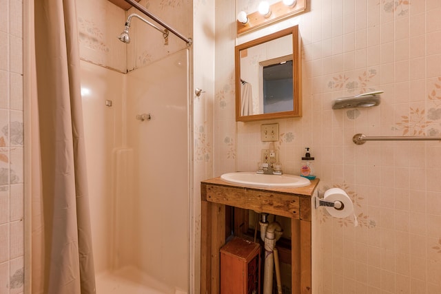 bathroom featuring sink, walk in shower, and tile walls