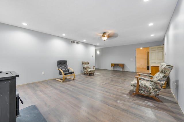 sitting room featuring wood-type flooring and ceiling fan