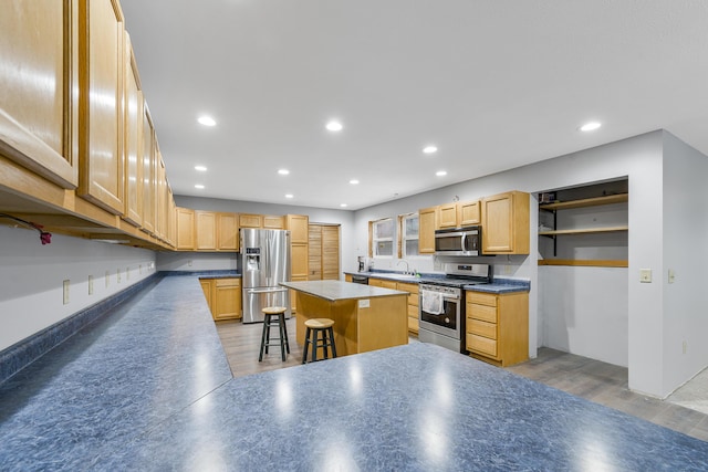 kitchen with a center island, sink, stainless steel appliances, dark hardwood / wood-style flooring, and a breakfast bar