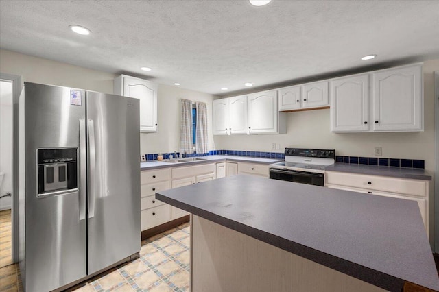 kitchen with electric range, white cabinetry, stainless steel refrigerator with ice dispenser, and a textured ceiling