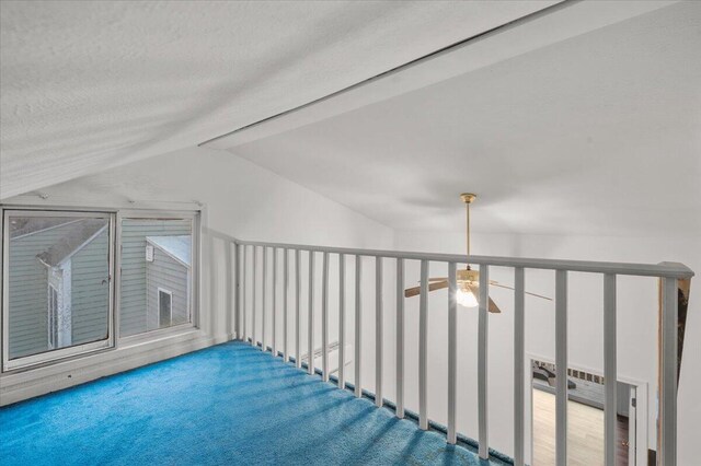 additional living space featuring lofted ceiling with beams and a textured ceiling