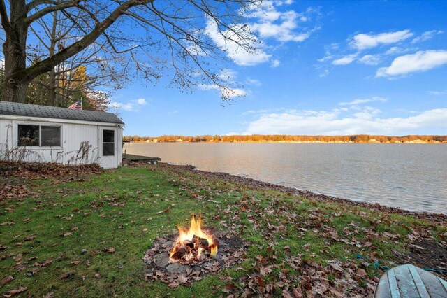 view of yard featuring a water view and a fire pit