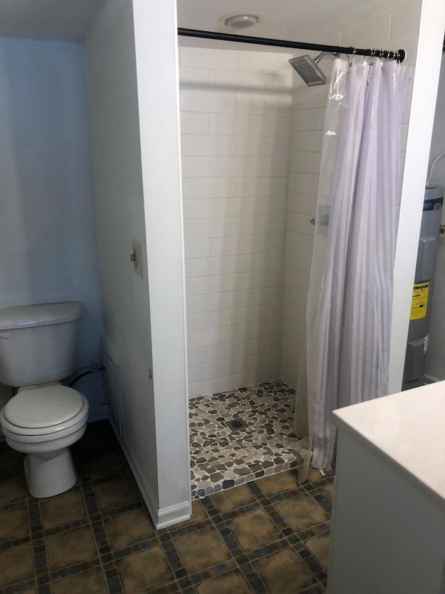 full bath with a stall shower, vanity, toilet, and baseboards