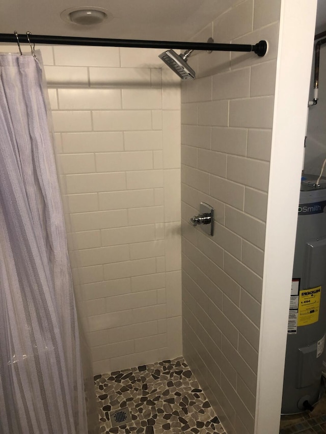 bathroom with water heater and a shower stall