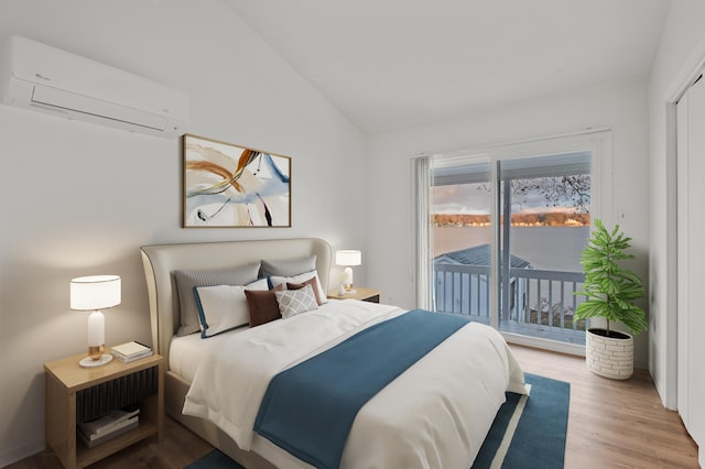 bedroom featuring lofted ceiling, access to outside, wood finished floors, and a wall mounted air conditioner