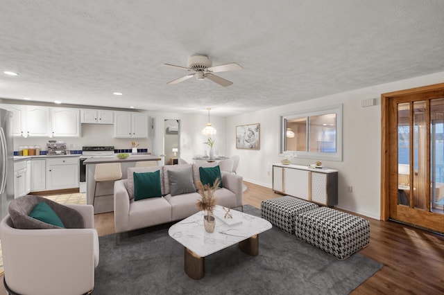 living area with light wood finished floors, baseboards, a textured ceiling, and recessed lighting