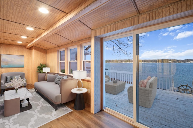 interior space with beamed ceiling, wooden ceiling, wood finished floors, and a water view