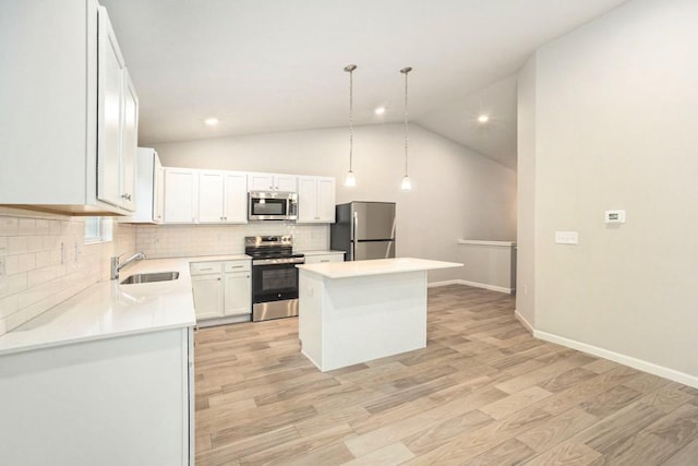 kitchen featuring white cabinetry, a center island, stainless steel appliances, light hardwood / wood-style flooring, and decorative light fixtures