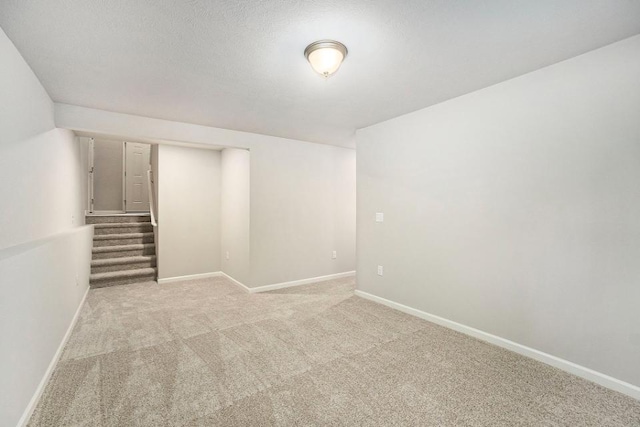 basement with a textured ceiling and light carpet