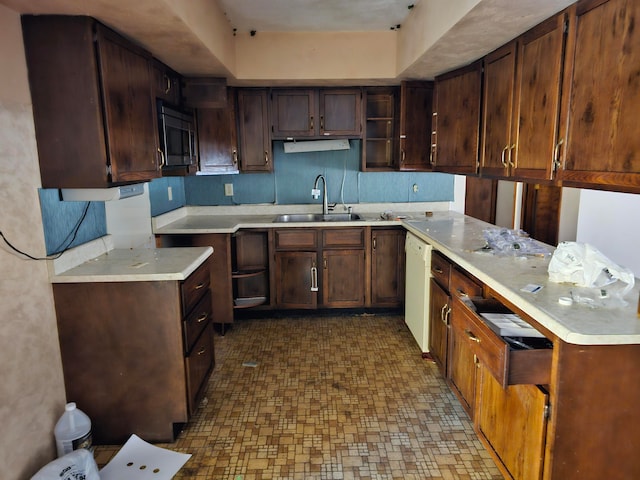 kitchen featuring a raised ceiling, dishwasher, sink, and dark brown cabinets