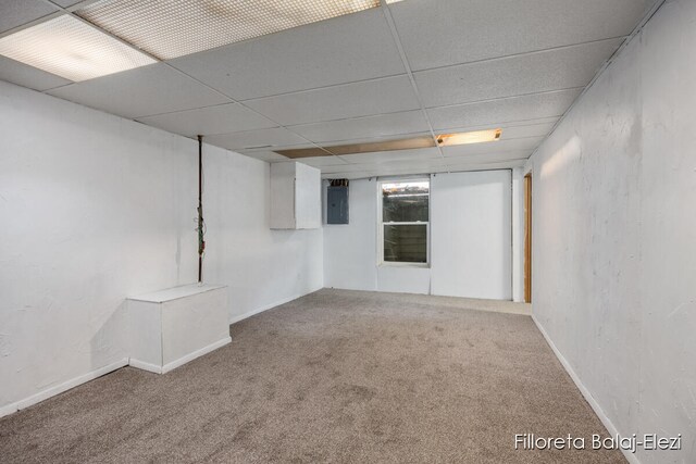 basement featuring carpet flooring, electric panel, and a drop ceiling