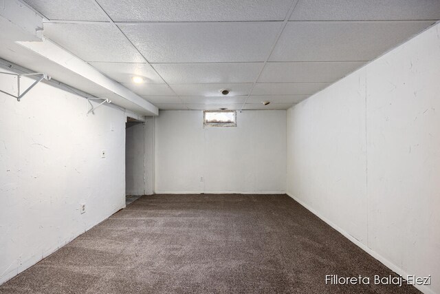 basement with a drop ceiling and carpet