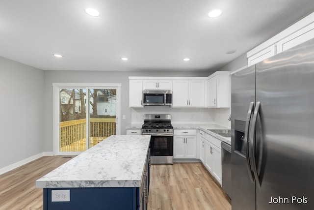 kitchen featuring white cabinets, a kitchen island, light hardwood / wood-style floors, and appliances with stainless steel finishes