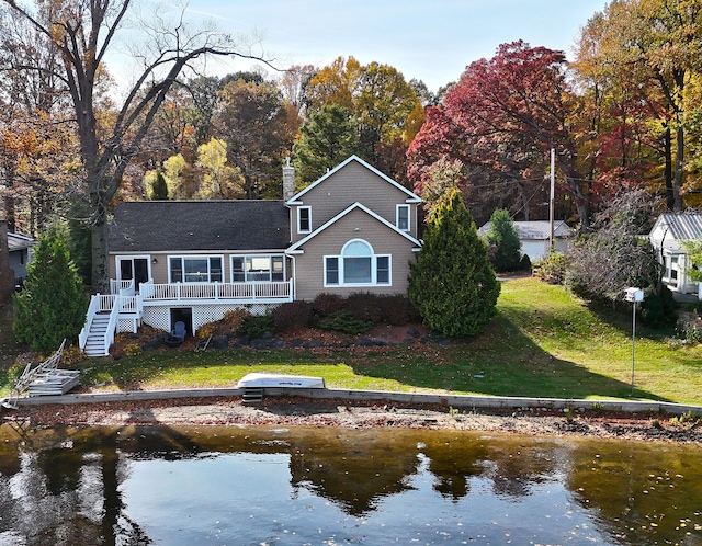 back of house featuring a yard and a water view