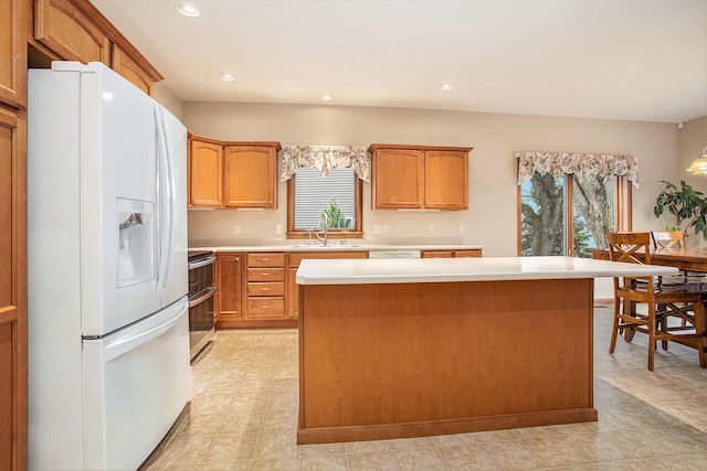 kitchen featuring stainless steel range, a wealth of natural light, white fridge with ice dispenser, and a kitchen island