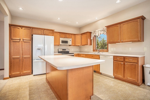 kitchen featuring white appliances, a kitchen island, and sink