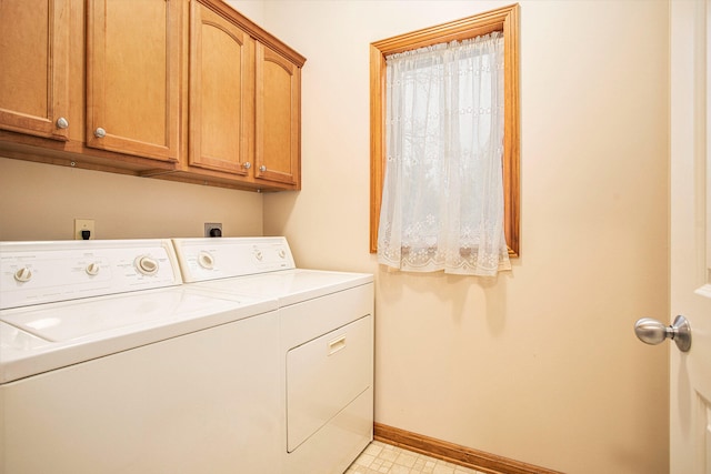 clothes washing area with cabinets and washing machine and dryer