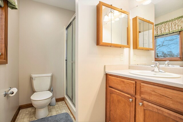 bathroom featuring vanity, toilet, and a shower with shower door