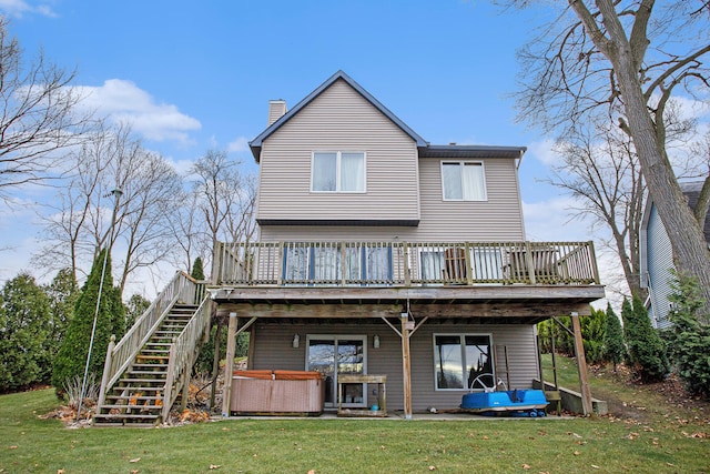 rear view of property featuring a patio area, a deck, a yard, and a hot tub