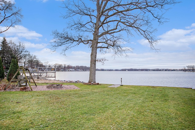 view of yard featuring a water view and a fire pit