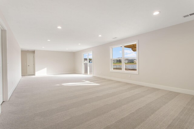 spare room featuring light colored carpet