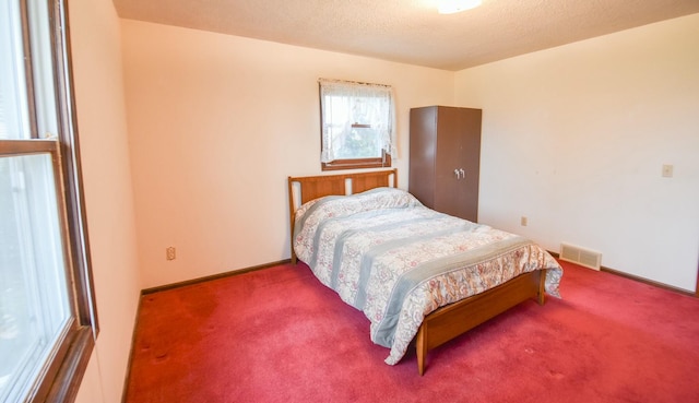 carpeted bedroom featuring a textured ceiling