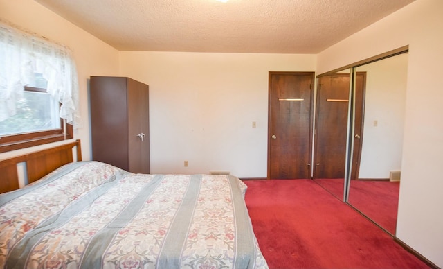 carpeted bedroom featuring a closet and a textured ceiling