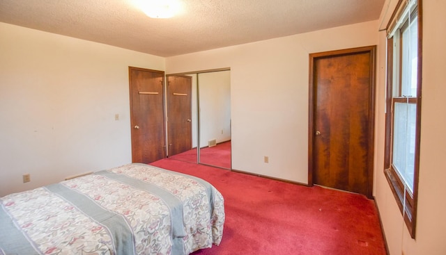 bedroom with carpet floors, a textured ceiling, and a closet